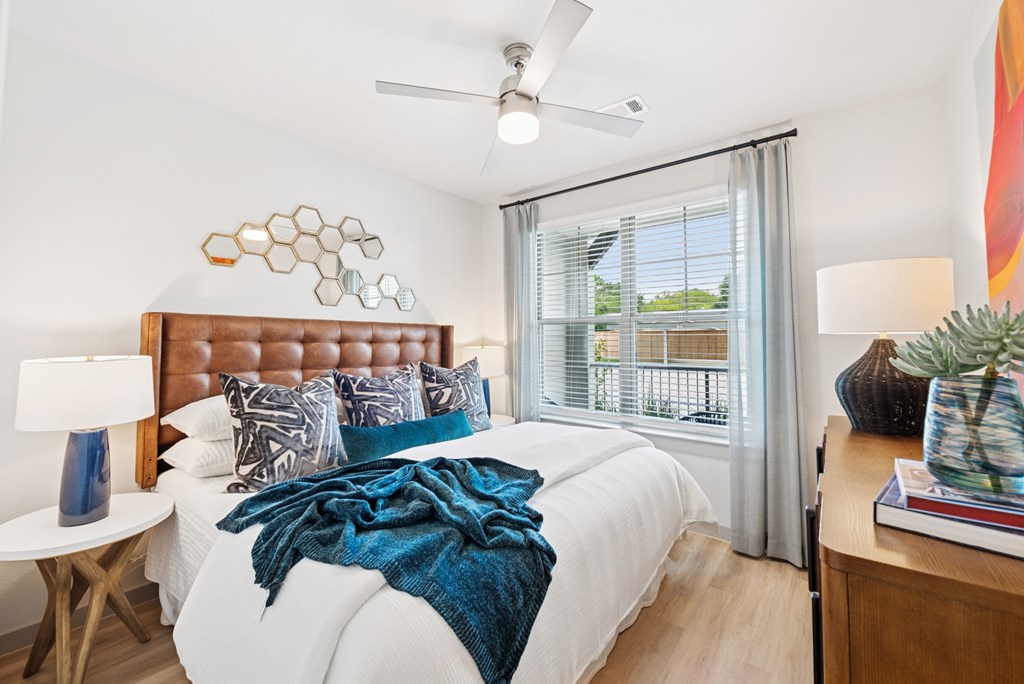 A bedroom with a white bed and a blue blanket.