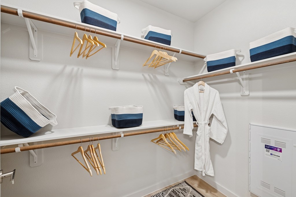 A white bathroom with a white robe hanging on a rack.
