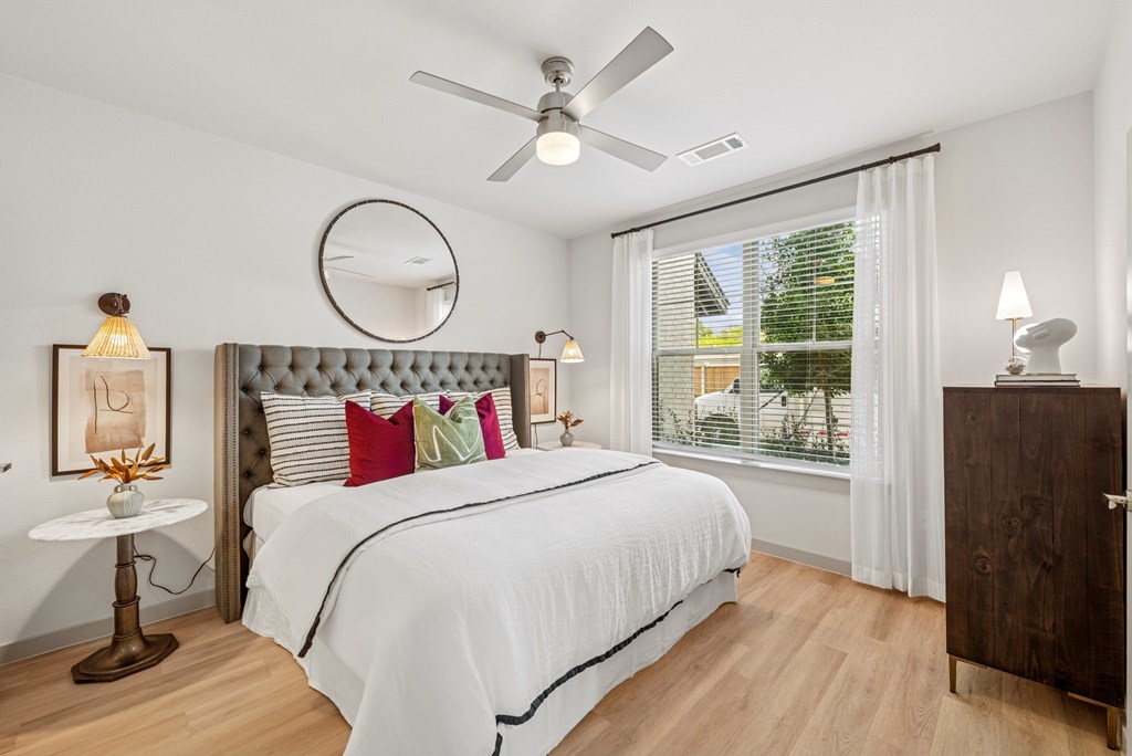 A bedroom with a large bed and a ceiling fan.