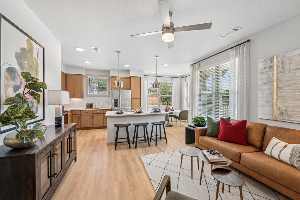 A modern living room with a kitchen area in the background.