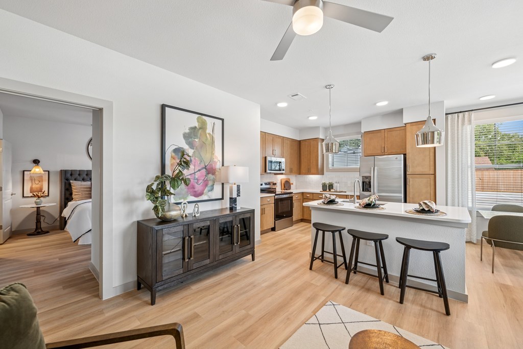 A modern kitchen with a bar stool and a framed picture on the wall.