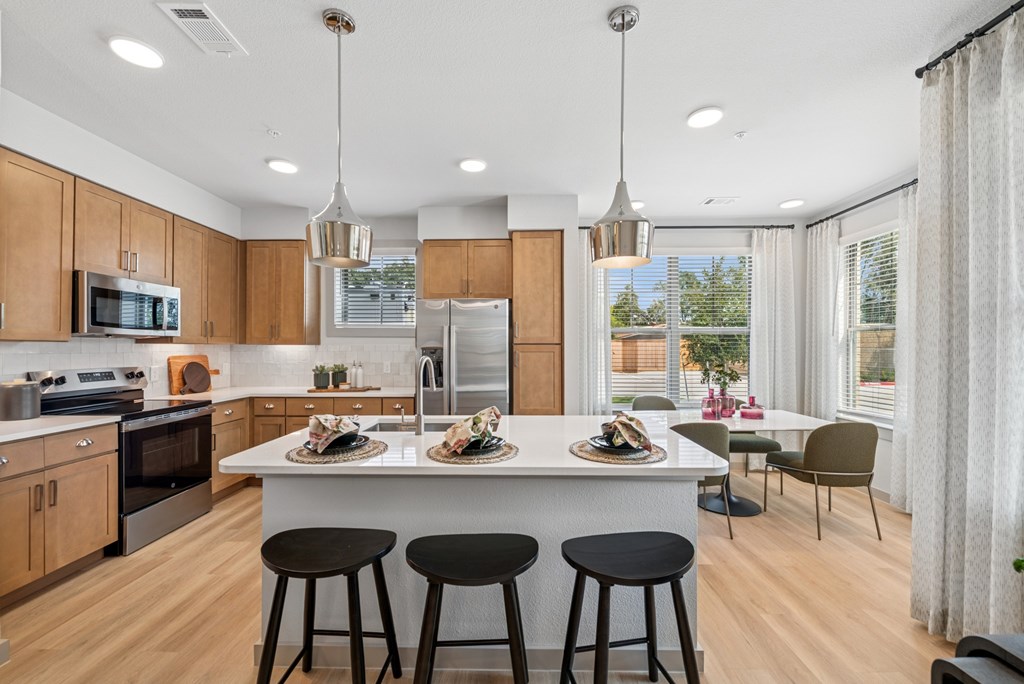 A modern kitchen with wooden cabinets and a large island.