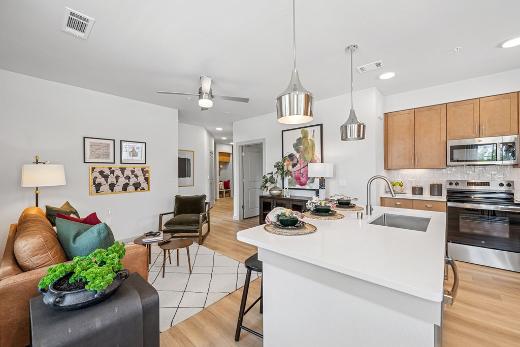 A modern kitchen with a dining area and a living room.