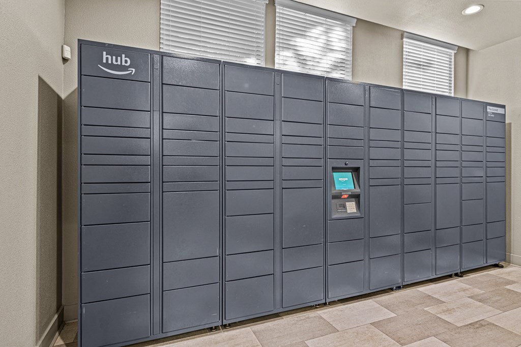 A row of Amazon hub vending machines are lined up against a wall.