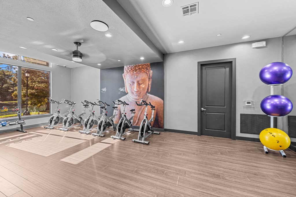 A gym with exercise bikes and a large poster on the wall.