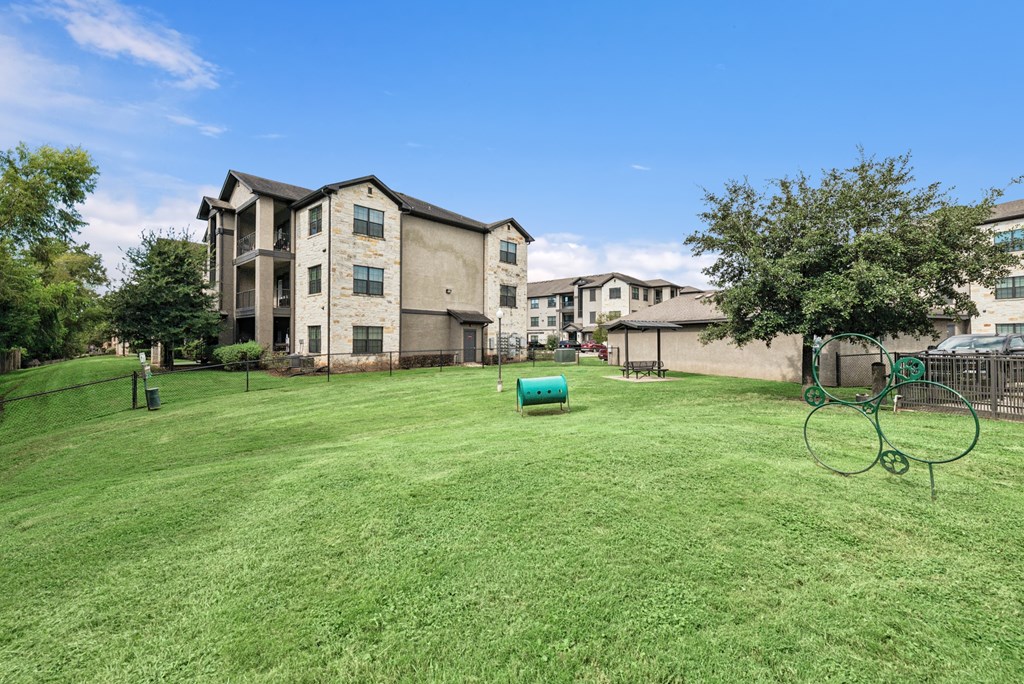A large grassy area in front of apartment buildings.