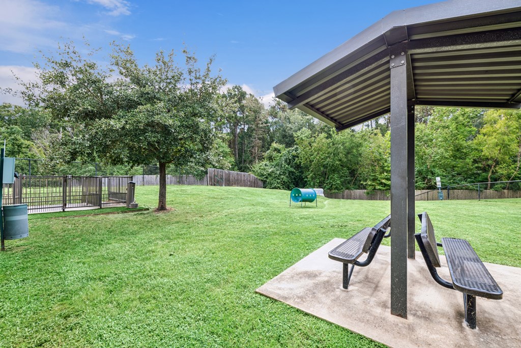A park with a picnic table and benches.