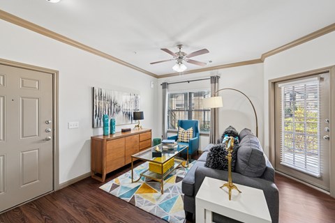 A living room with a grey couch and a yellow coffee table.