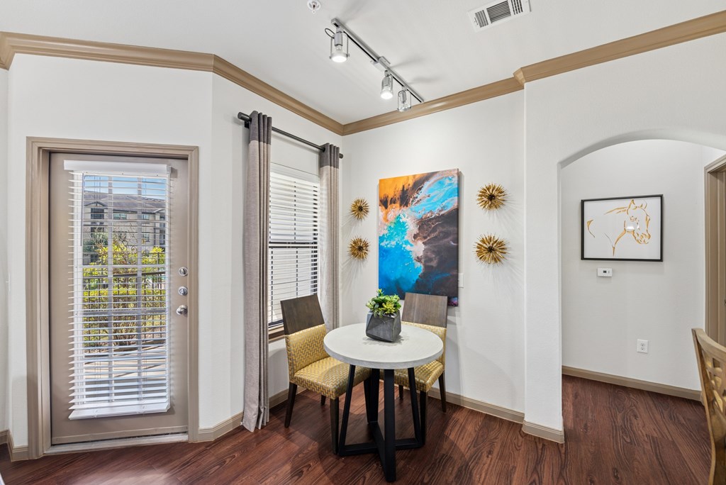 A dining room with a table and chairs.