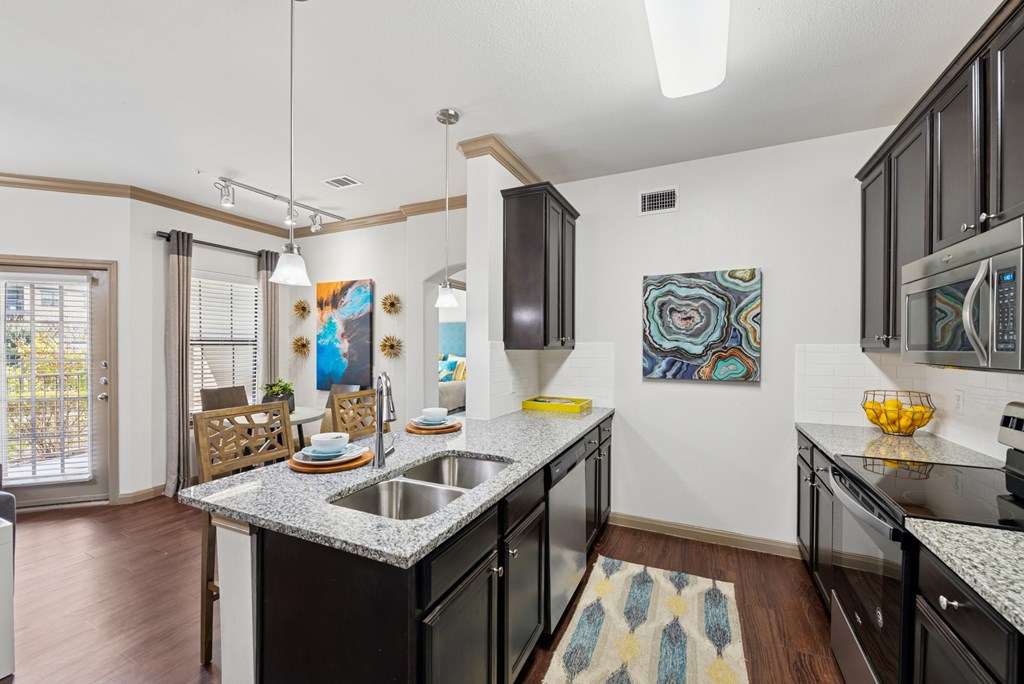 A kitchen with black cabinets and a white counter top.