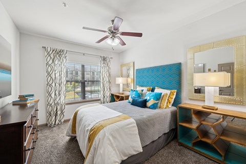 A bedroom with a large bed and a ceiling fan.