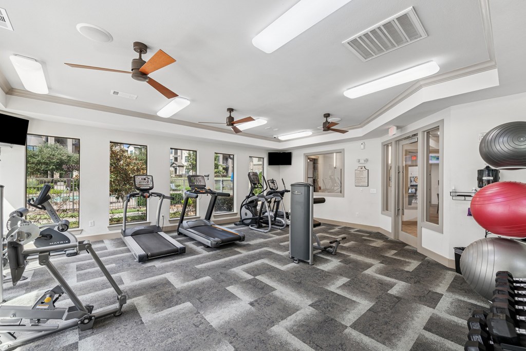 A spacious gym with treadmills, elliptical machines, and other exercise equipment.