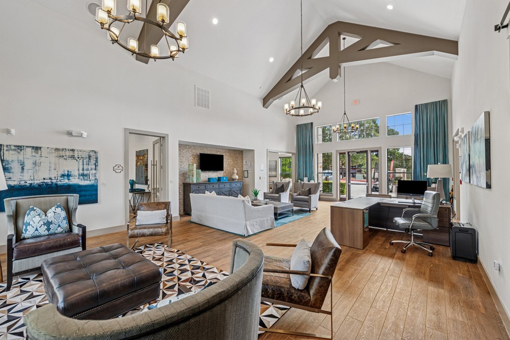 A large, well-furnished living room with a variety of seating options and a chandelier.