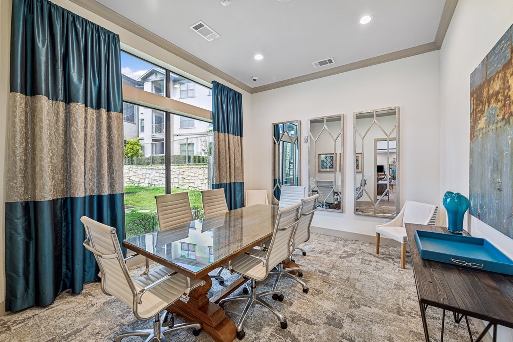 A conference room with a long table and chairs.