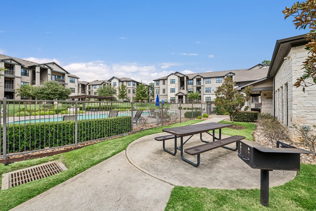 A picnic table sits in the middle of a concrete courtyard.