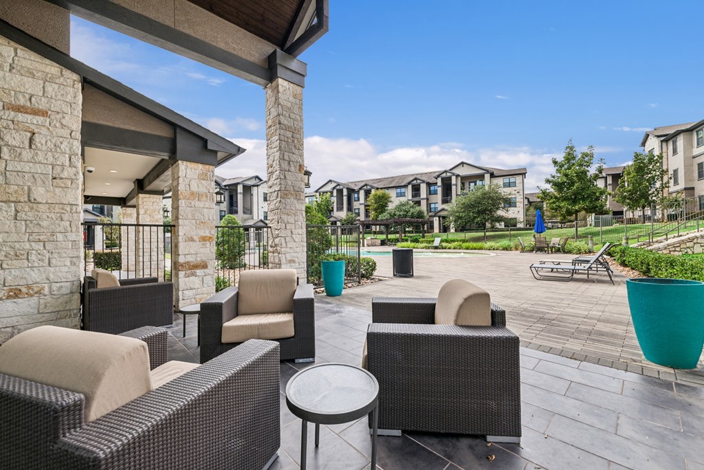 A patio with a table and chairs is surrounded by apartment buildings.