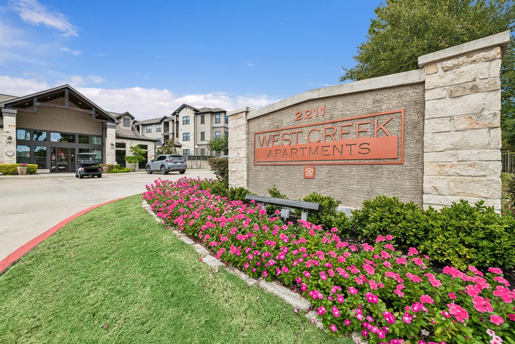 West Creek Apartments is a beautiful apartment complex with a well-maintained garden in front.
