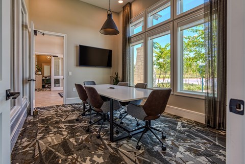 A conference room with a large table and chairs.