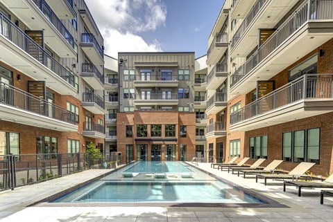 A large swimming pool in the middle of a courtyard surrounded by apartment buildings.