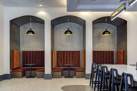 A modern dining area with wooden booths and black chairs.