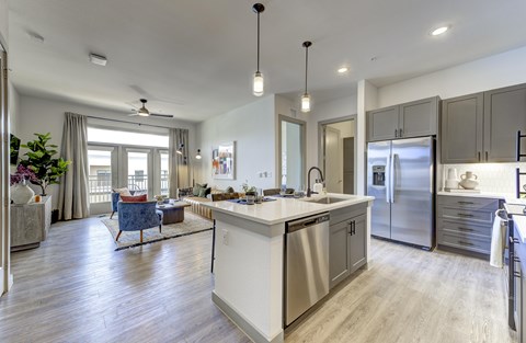 A modern kitchen with a large island and stainless steel appliances.