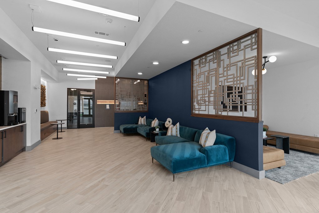 a living room with blue couches and a blue accent wall and a wooden floor