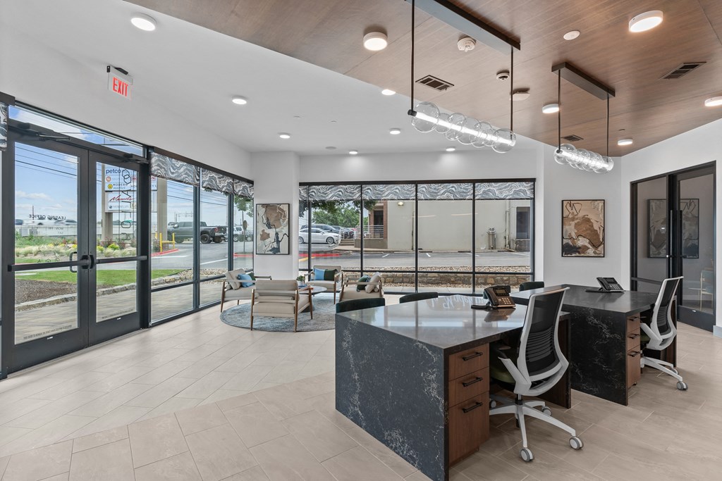 a large office with a desk and chairs in front of windows