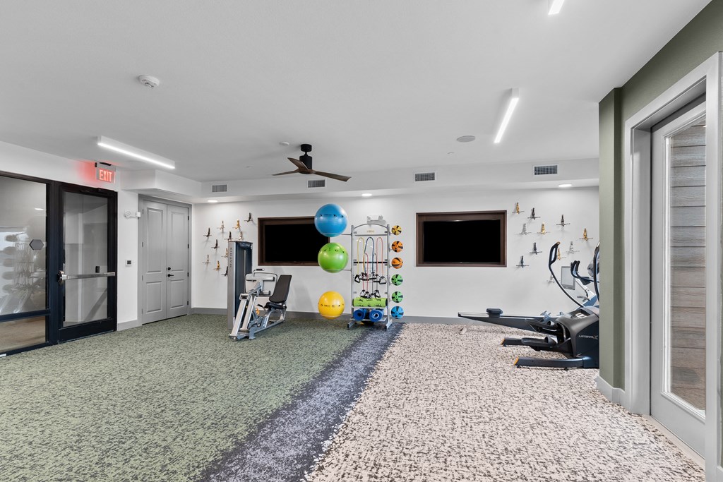 a workout room with weights and a television on the wall