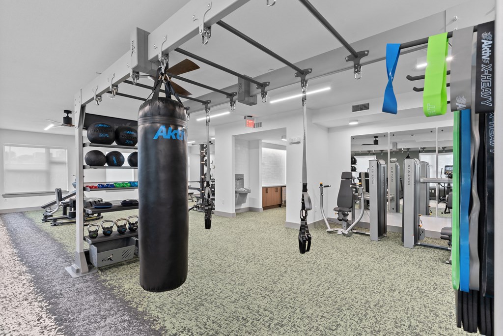 a fitness room with a punching bag and weights on the floor