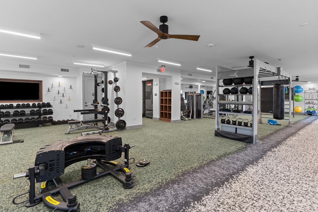 a gym with weights machines and a ceiling fan