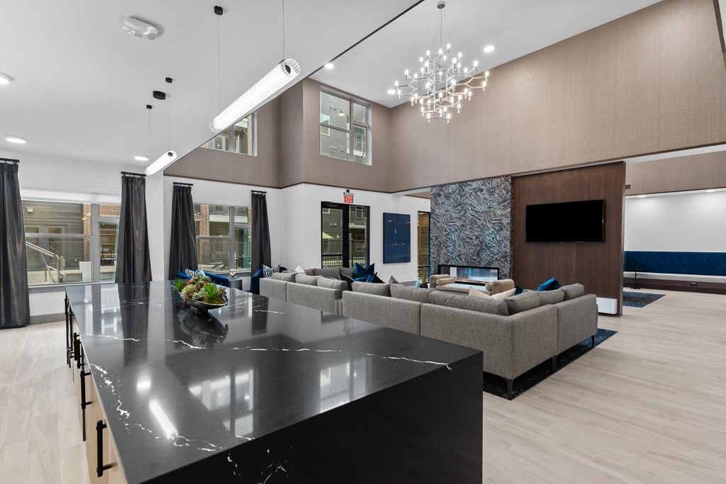 a large living room with couches and a kitchen with a large island