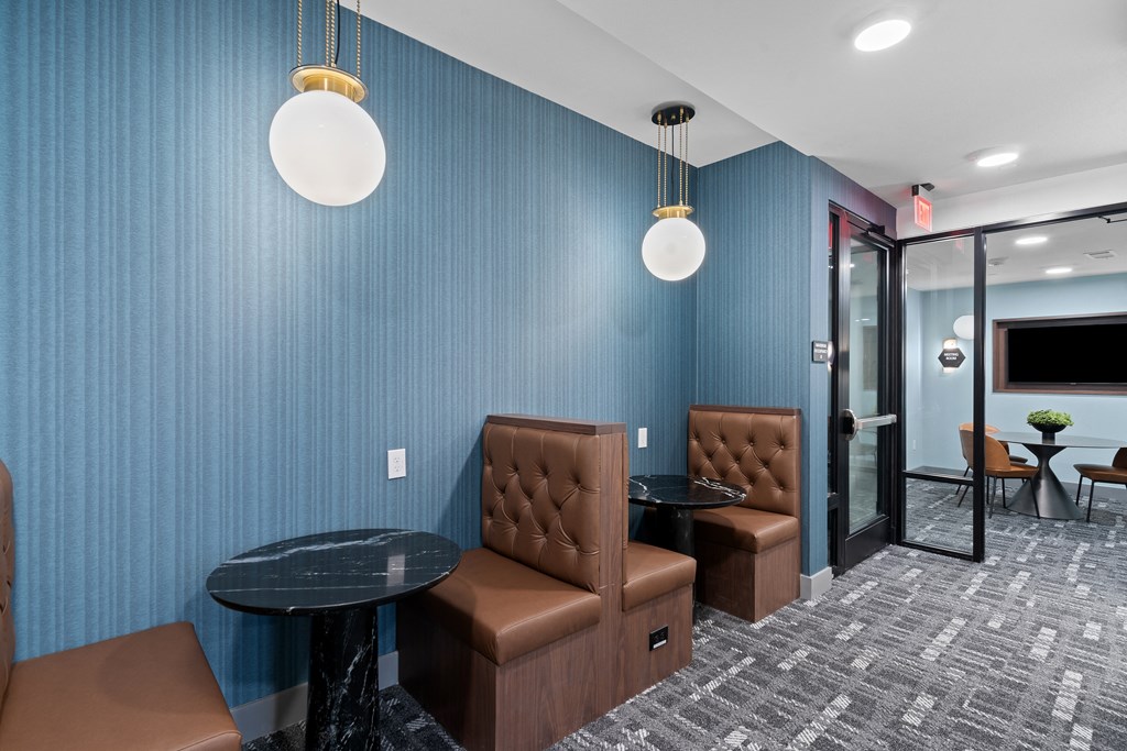 room with couches and tables in front of a blue wall