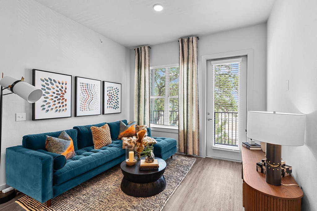 a living room with a blue couch and a door to a balcony