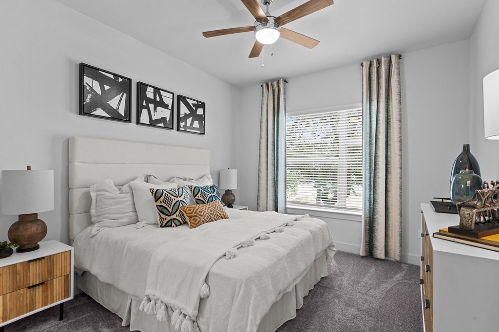 a bedroom with a large bed and a ceiling fan