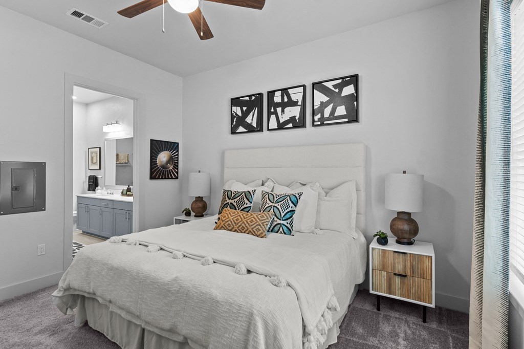 a bedroom with a white bed and a ceiling fan