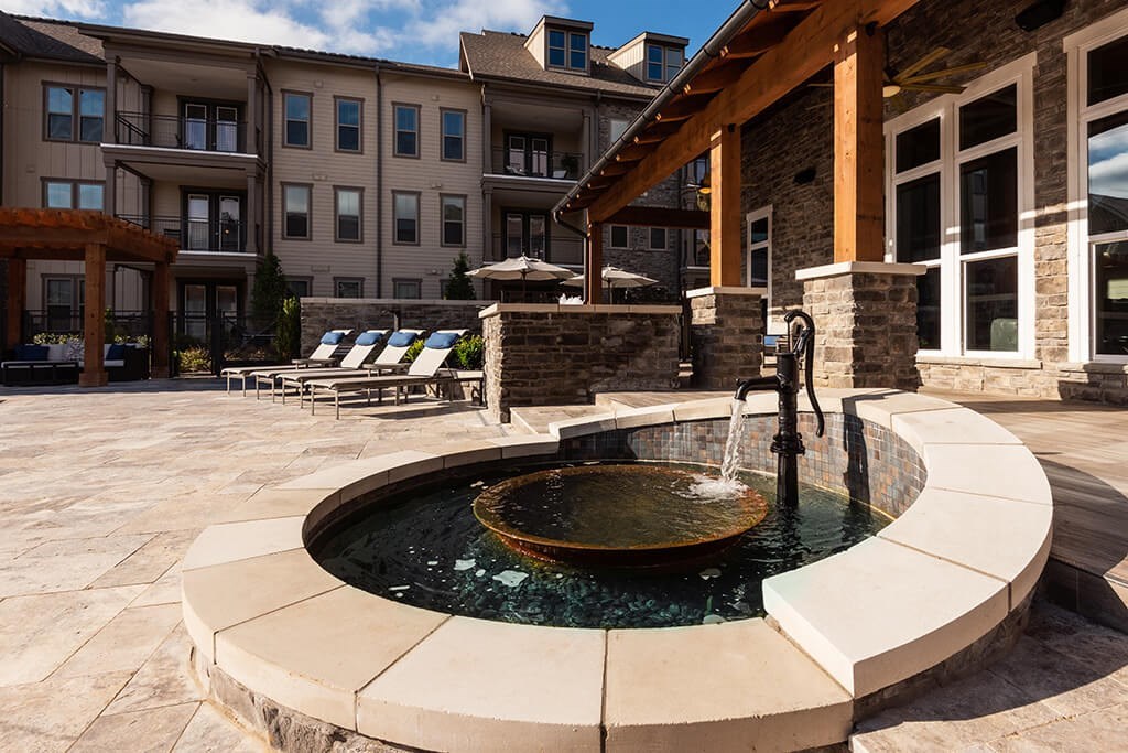 A small fountain in the middle of a patio.