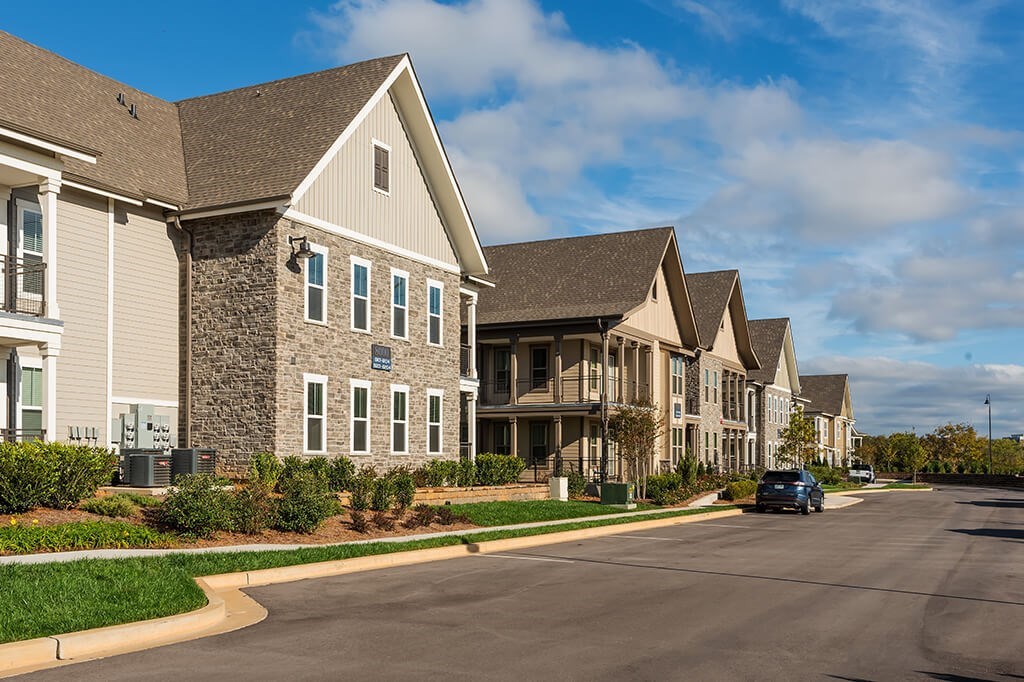 A row of houses with a car parked on the street.