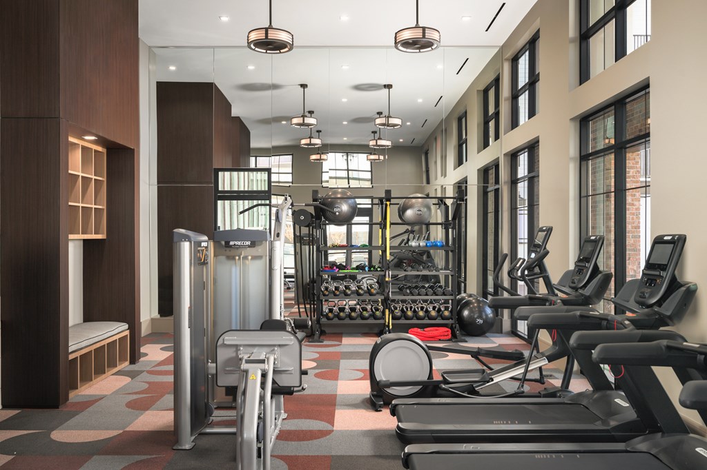 A gym with treadmills, elliptical machines, and other exercise equipment.
