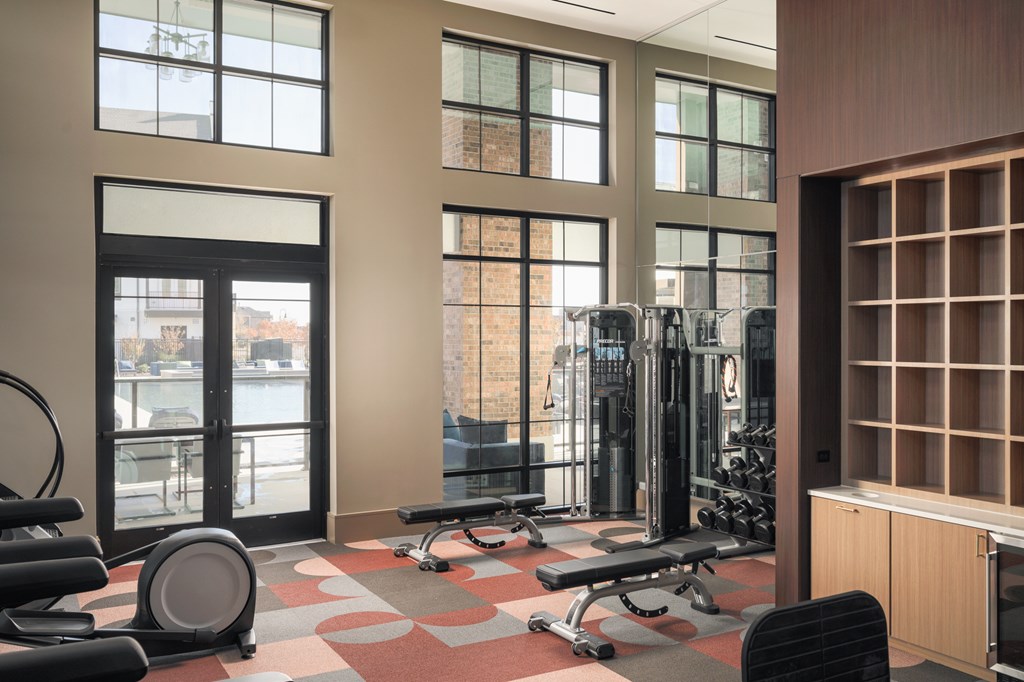 A gym with a variety of equipment including weights and cardio machines.