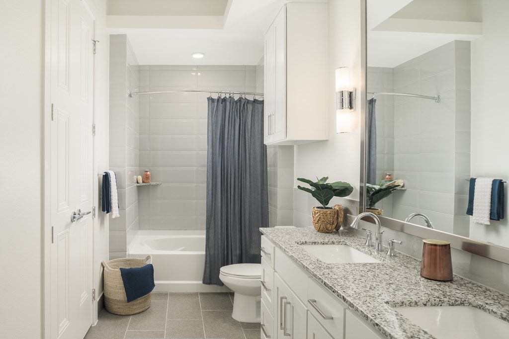 A bathroom with a white tub, sink, and toilet.
