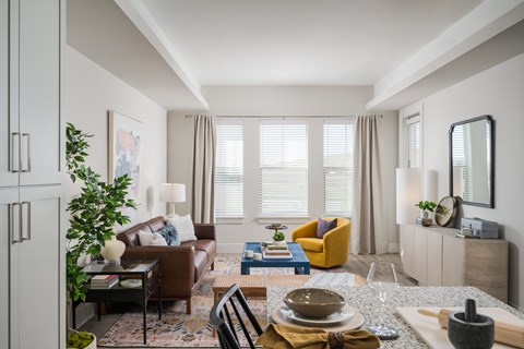 A well-lit, modern living room with a dining table set for two.