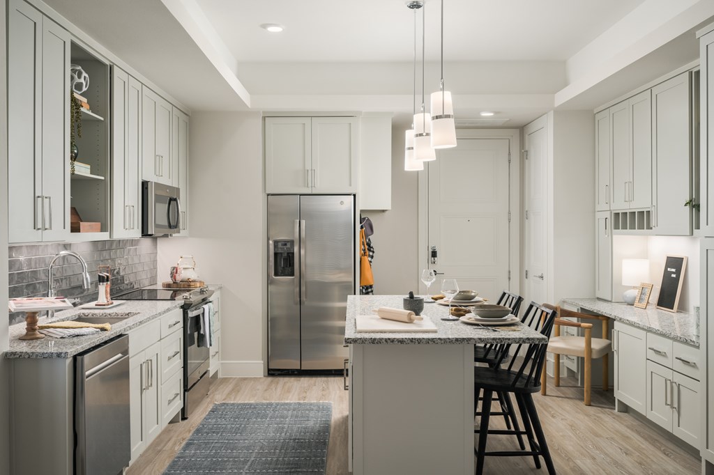A modern kitchen with a large island and stainless steel appliances.