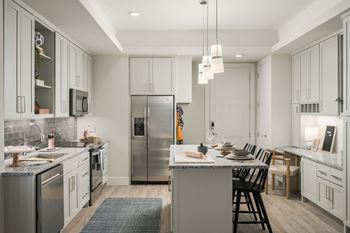 A modern kitchen with a large island and stainless steel appliances.