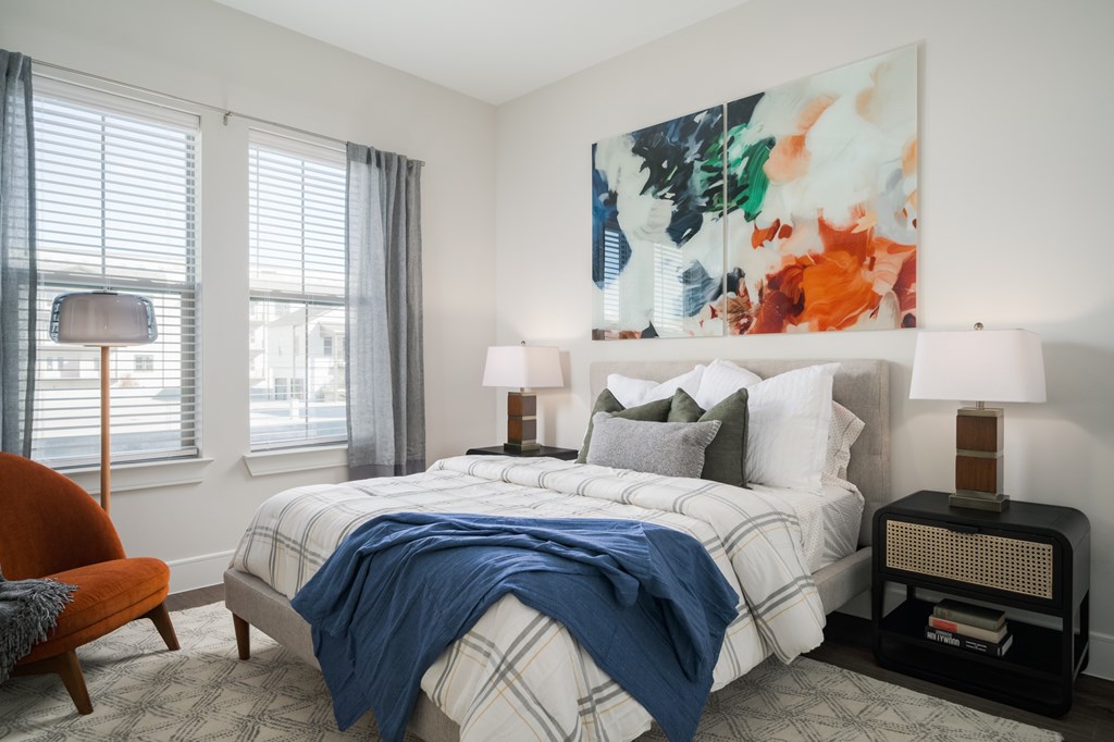 A bedroom with a large bed and a painting on the wall.
