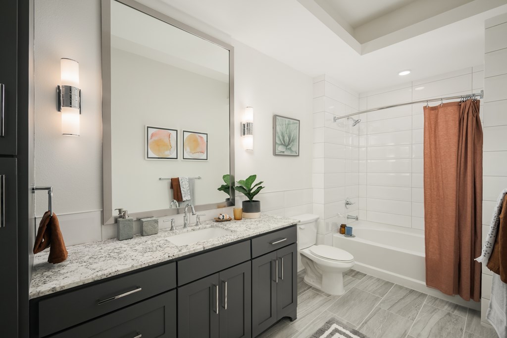 A bathroom with a marble countertop and a toilet.