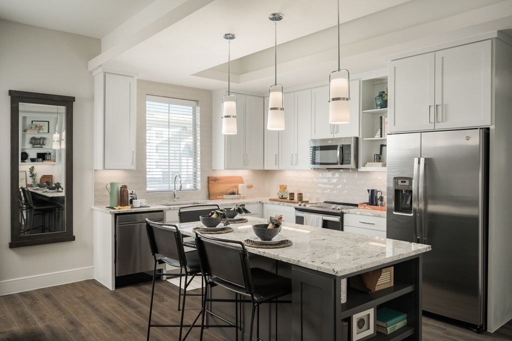 A modern kitchen with a large island and stainless steel appliances.