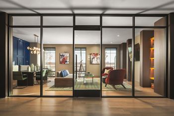 A modern living room with a glass door and a red chair.