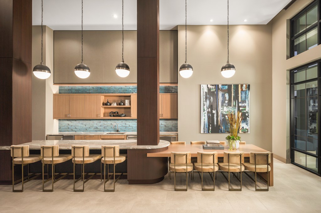 A modern dining room with a long table and chairs.