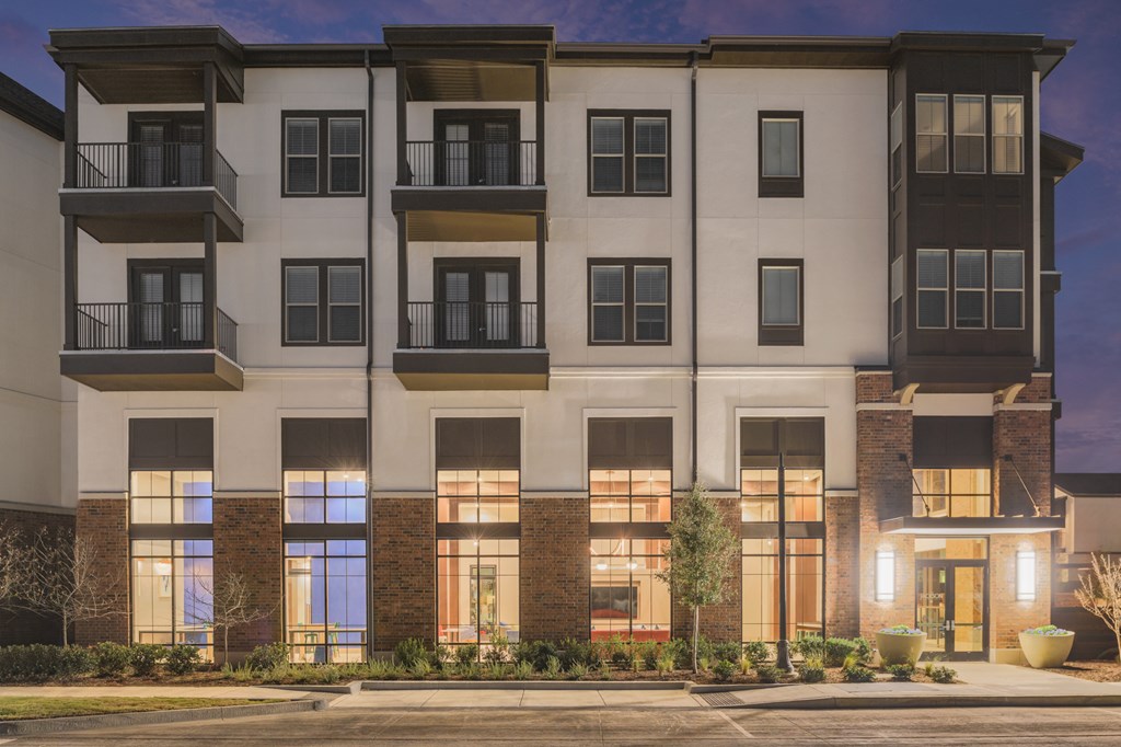 A modern apartment building with balconies and large windows.