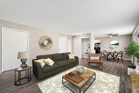 A living room with a grey couch, a coffee table, and a dining table with chairs.
